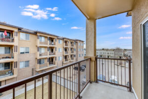 Exterior Unit patio, view of courtyard and parking lot, metal railing, covered patio.